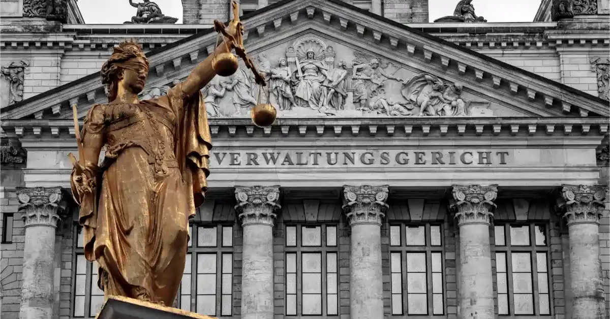 Goldene Justitia-Statue vor der Fassade eines Verwaltungsgerichts, Symbolbild für die Verwaltungsgerichtsbarkeit
